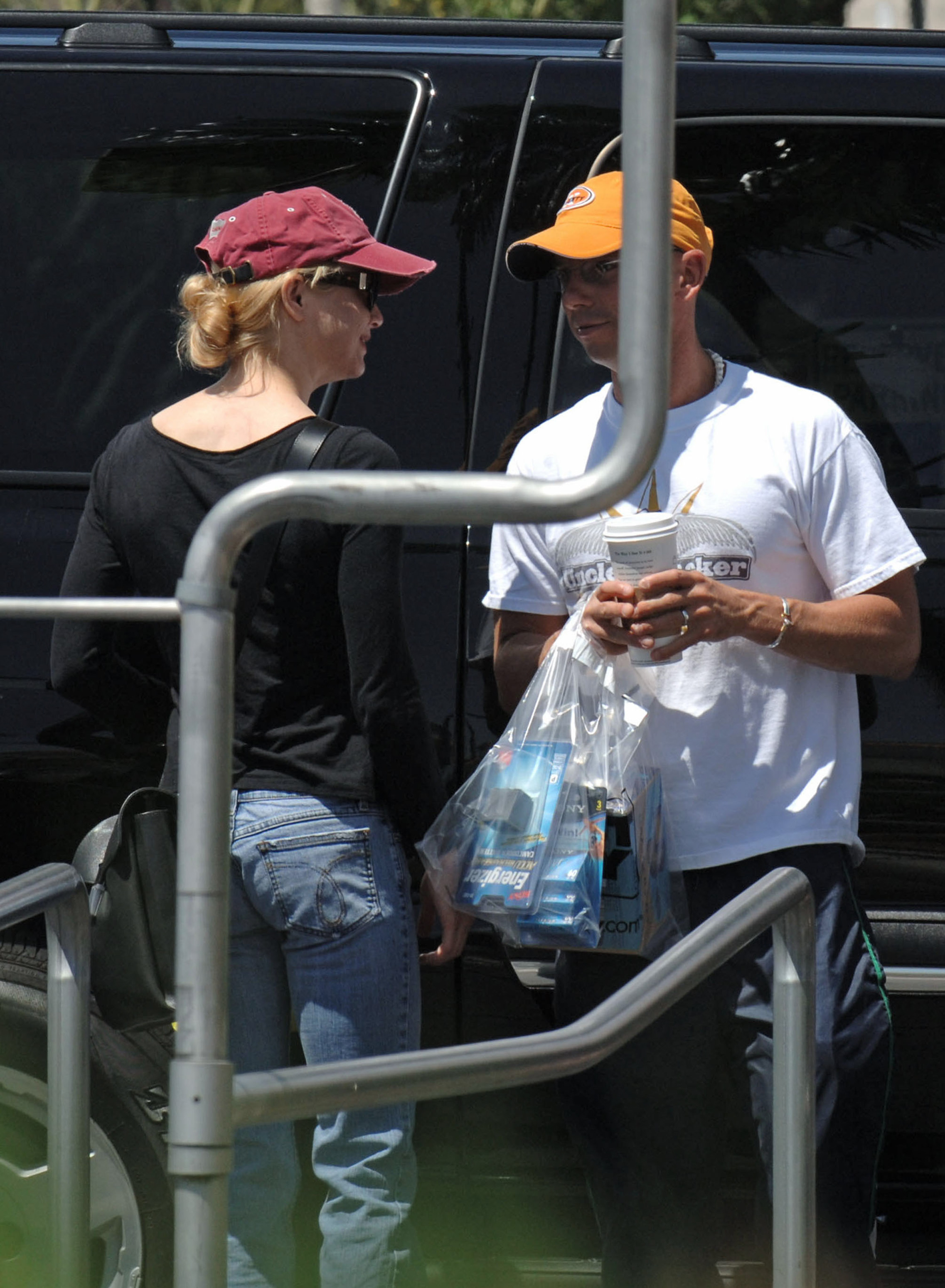 Renée Zellweger et Kenny Chesney aperçus à Las Vegas le 18 mai 2005. Zellweger portait un haut noir à manches longues et un jean, tandis que Chesney, vêtu d'un t-shirt blanc et d'une casquette jaune, portait des sacs de courses et un gobelet de café.
