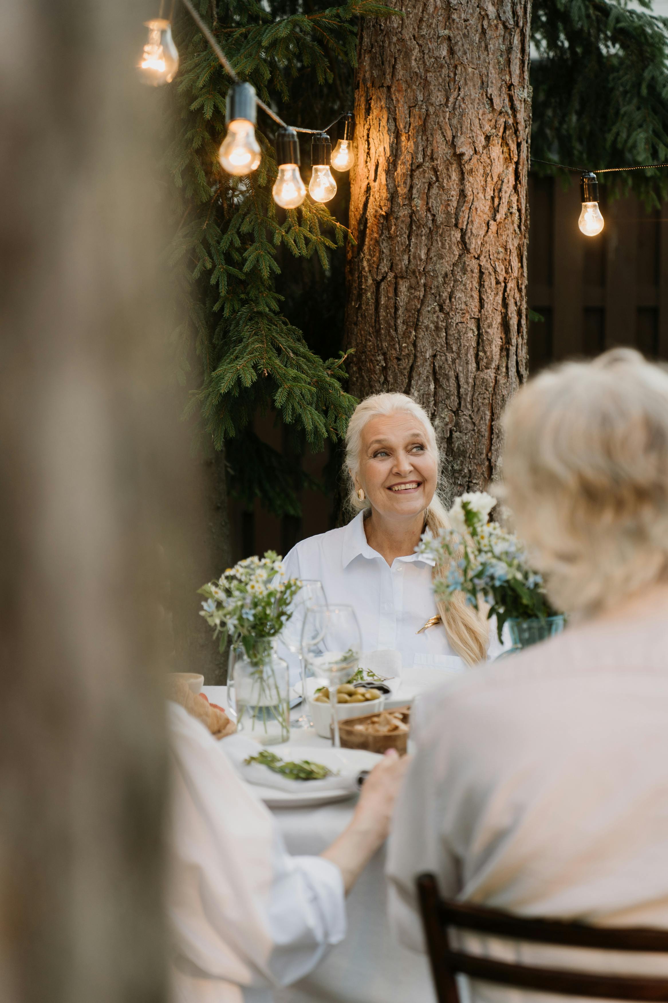 Une femme heureuse dégustant un repas avec d'autres personnes | Source : Pexels
