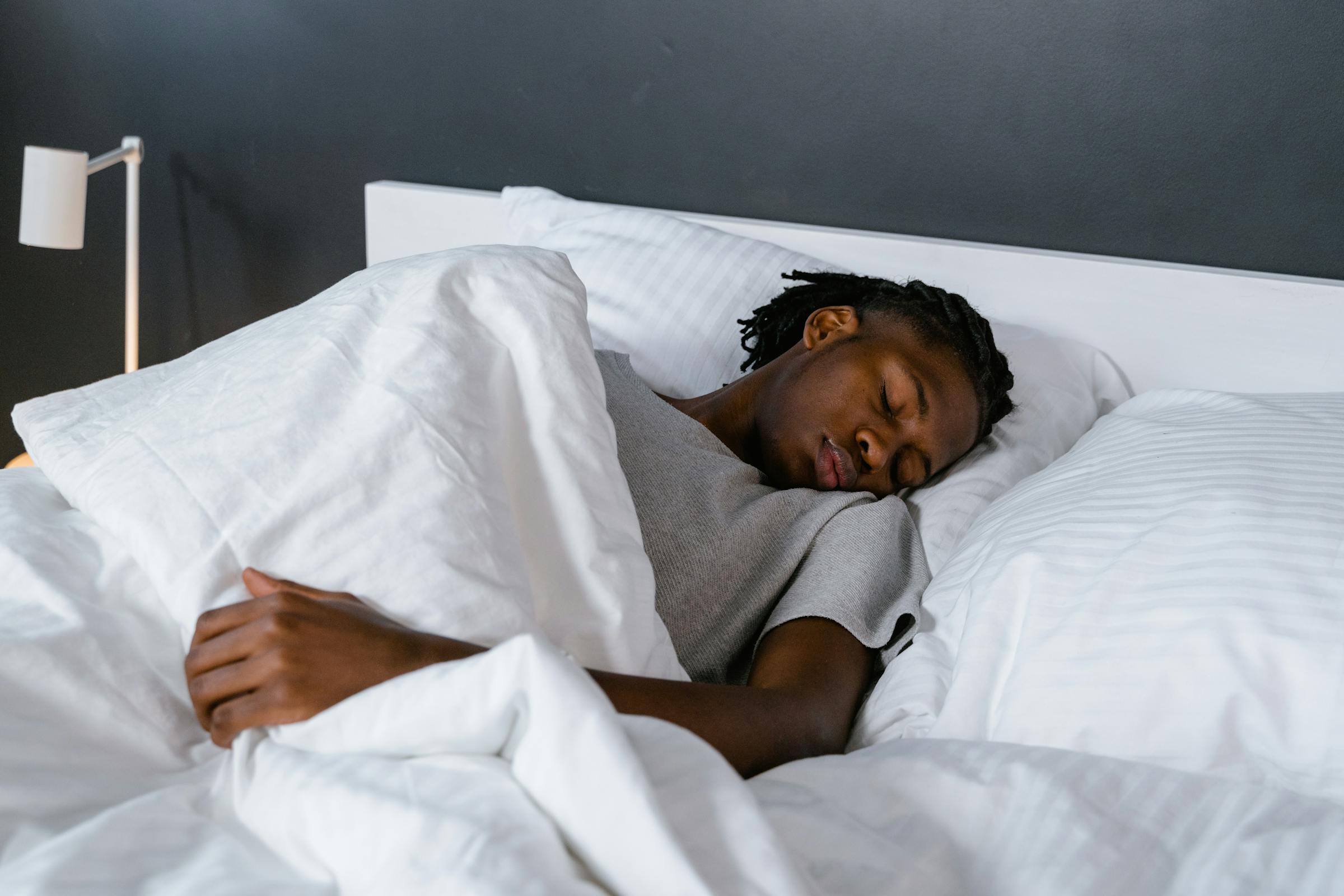 Un homme dormant dans un lit | Source : Pexels