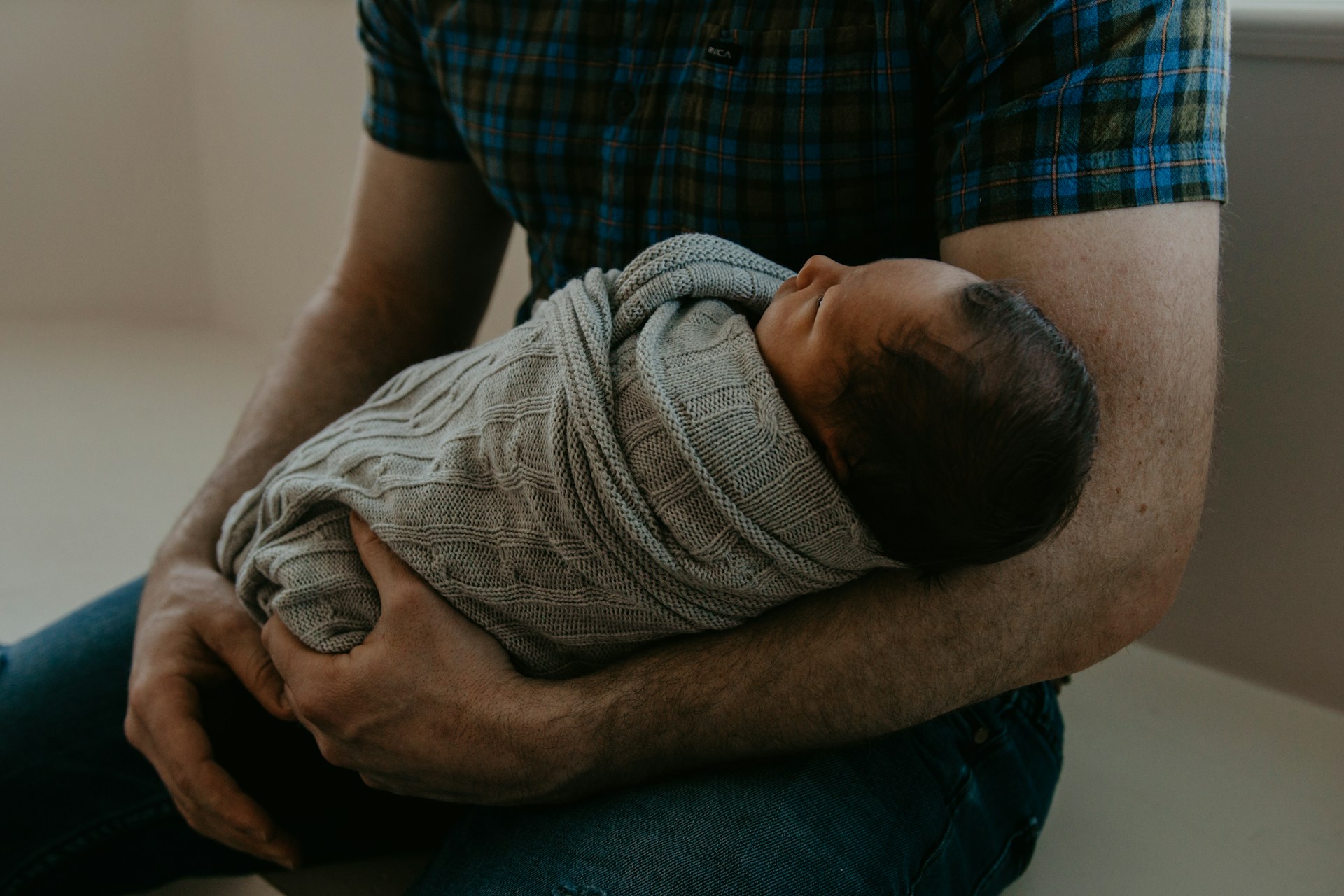 Un homme tenant un bébé | Source : Unsplash