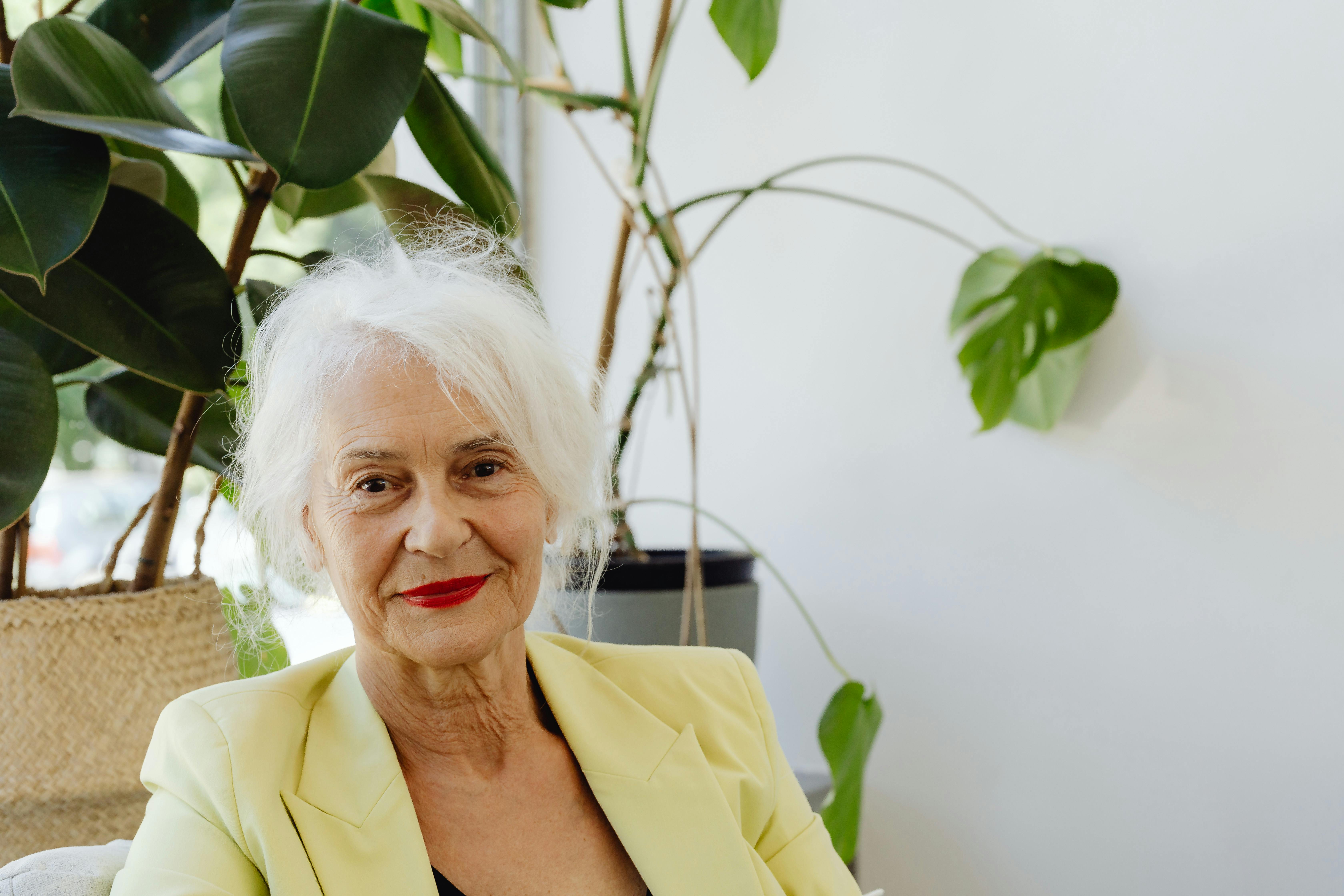 Une vieille dame souriante portant un blazer jaune | Source : Pexels