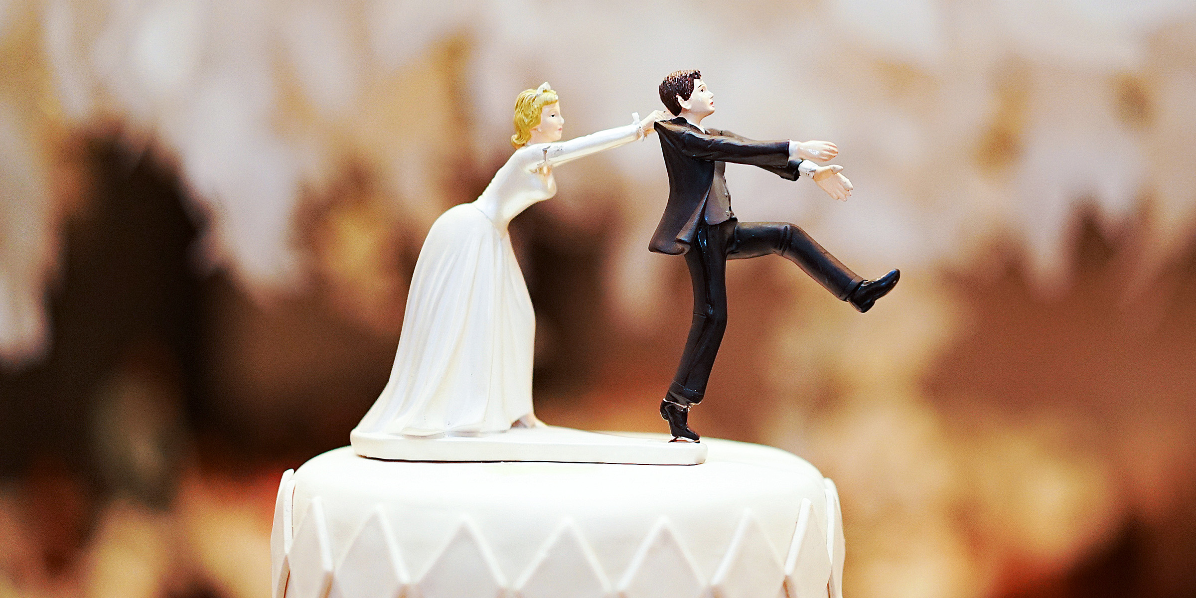 Des figurines représentant les mariés sur un gâteau | Source : Shutterstock