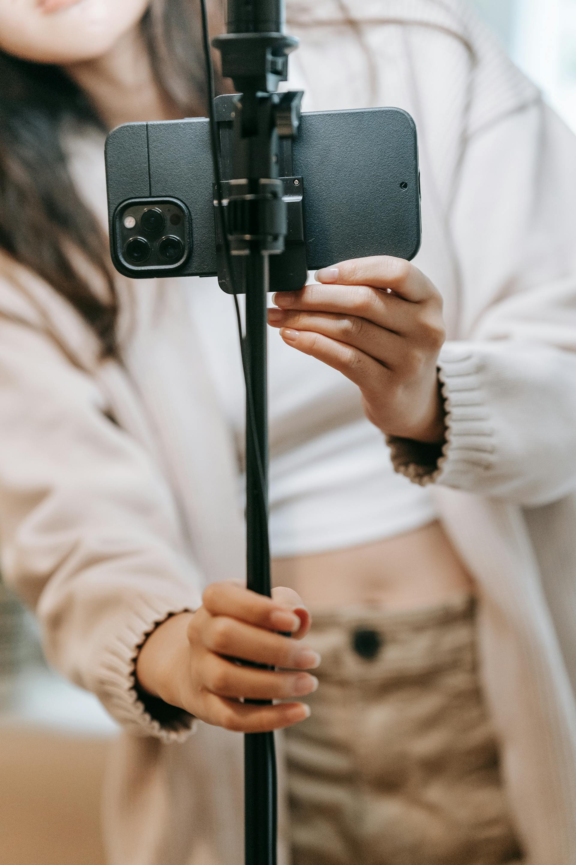 Quelqu'un tenant un téléphone sur un bâton à selfie | Source : Pexels