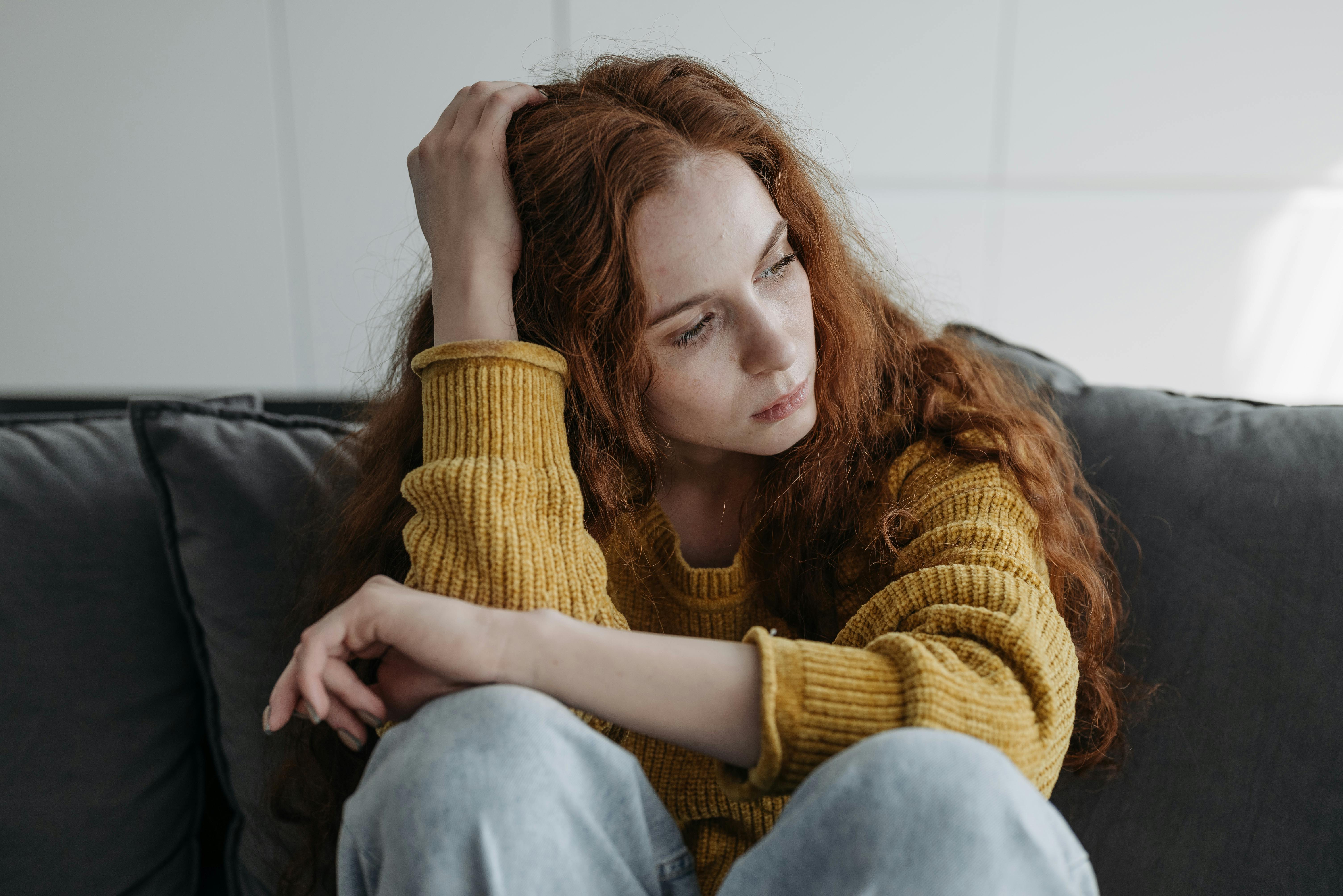 Une femme assise sur un canapé | Source : Pexels