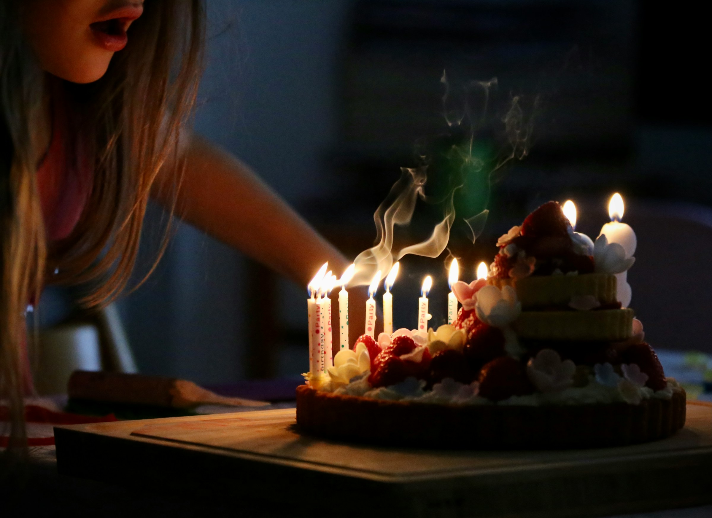 Une femme soufflant sur des bougies | Source : Unsplash