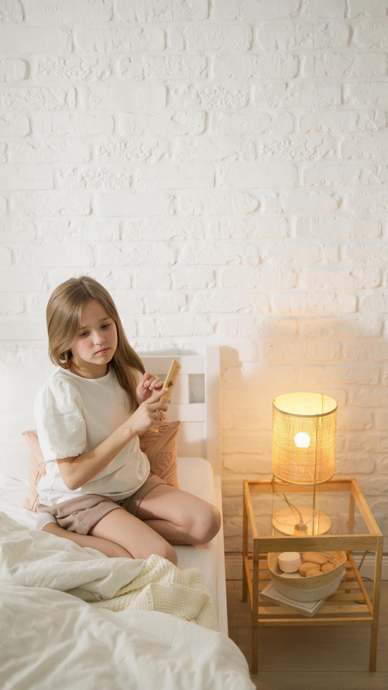 Une jeune fille triste se coiffant | Source : Pexels