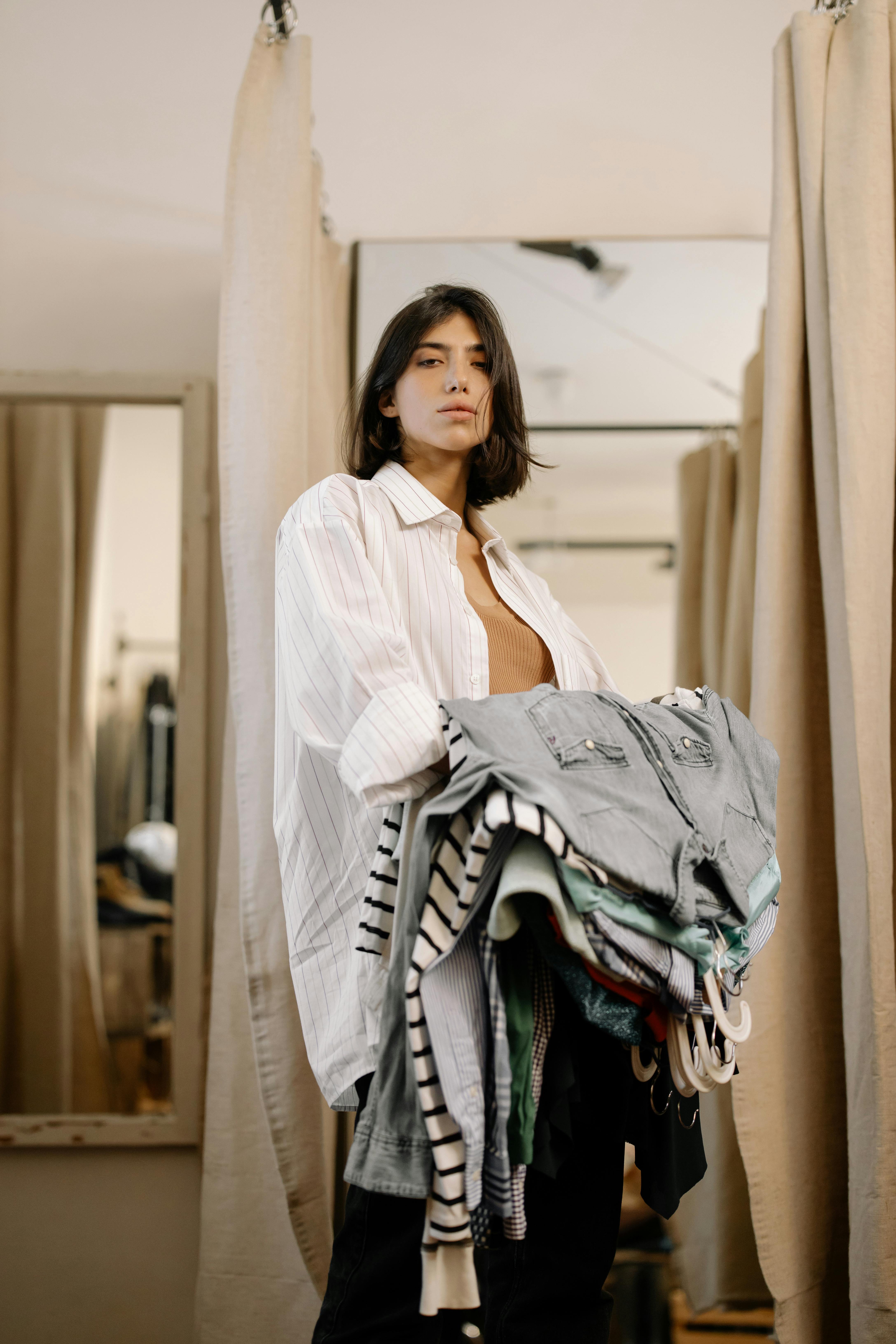 Une femme tient des vêtements | Source : Pexels
