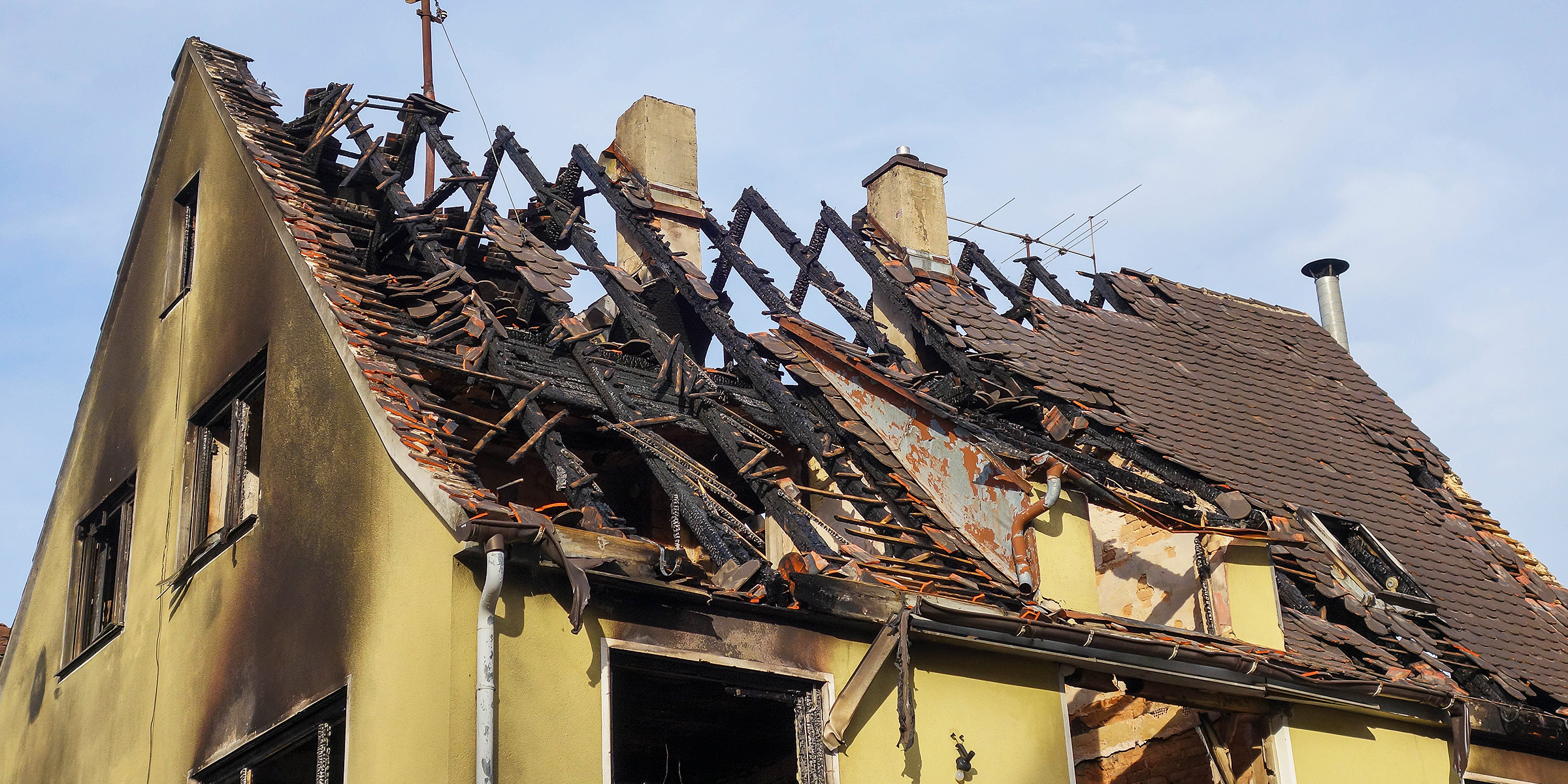 Toit effondré d'un bâtiment partiellement brûlé | Source : Shutterstock
