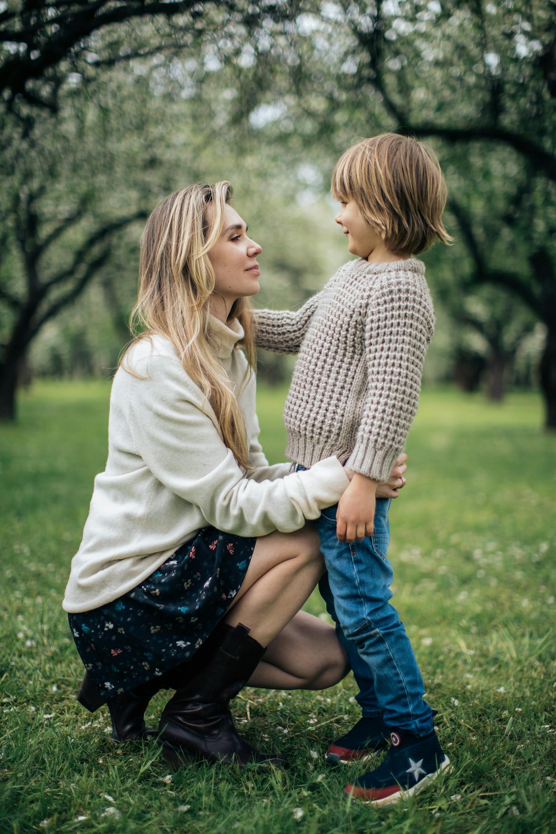 Une femme debout sur un champ d'herbe avec son fils | Source : Pexels