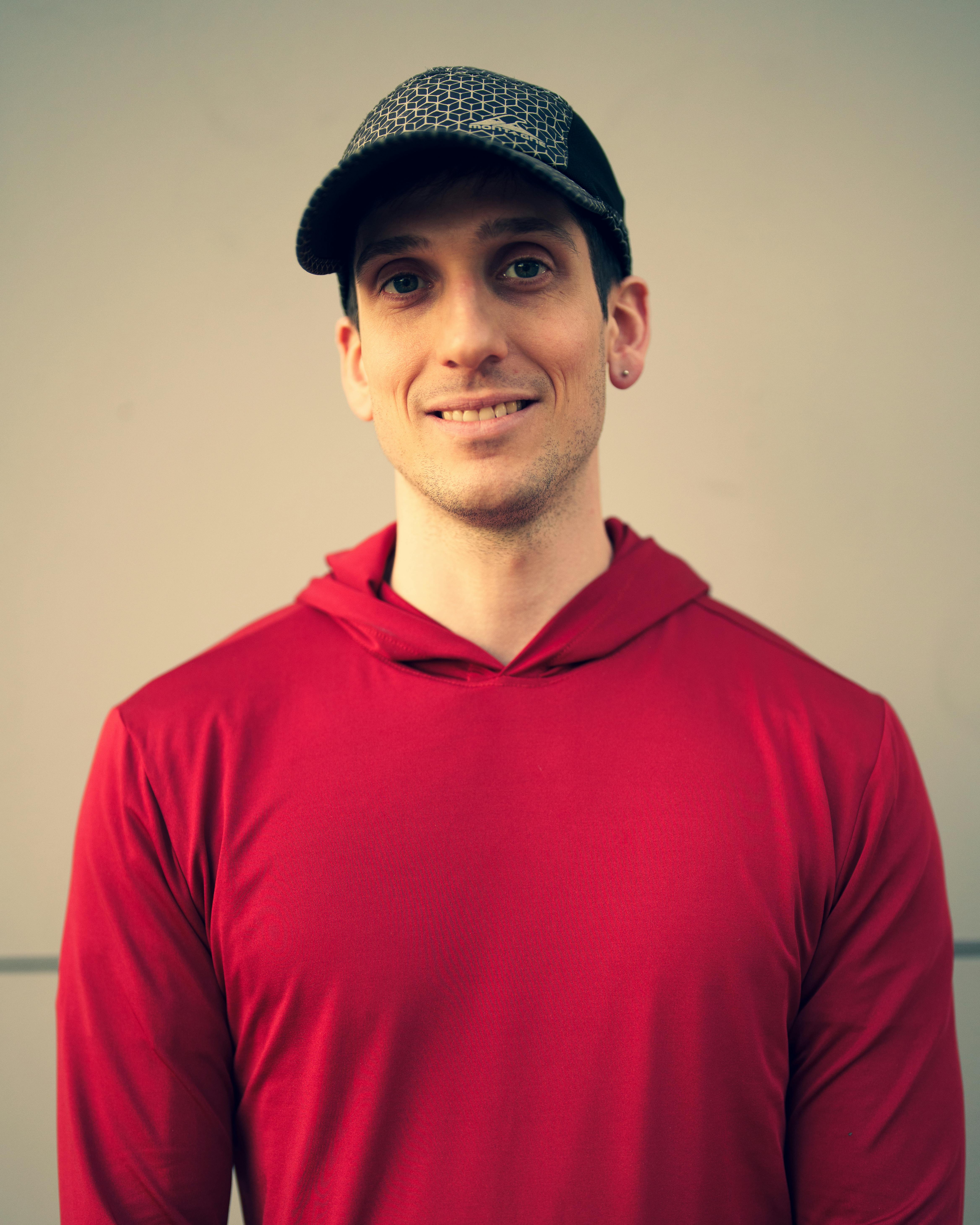 Un homme souriant avec un sweat à capuche rouge | Source : Pexels