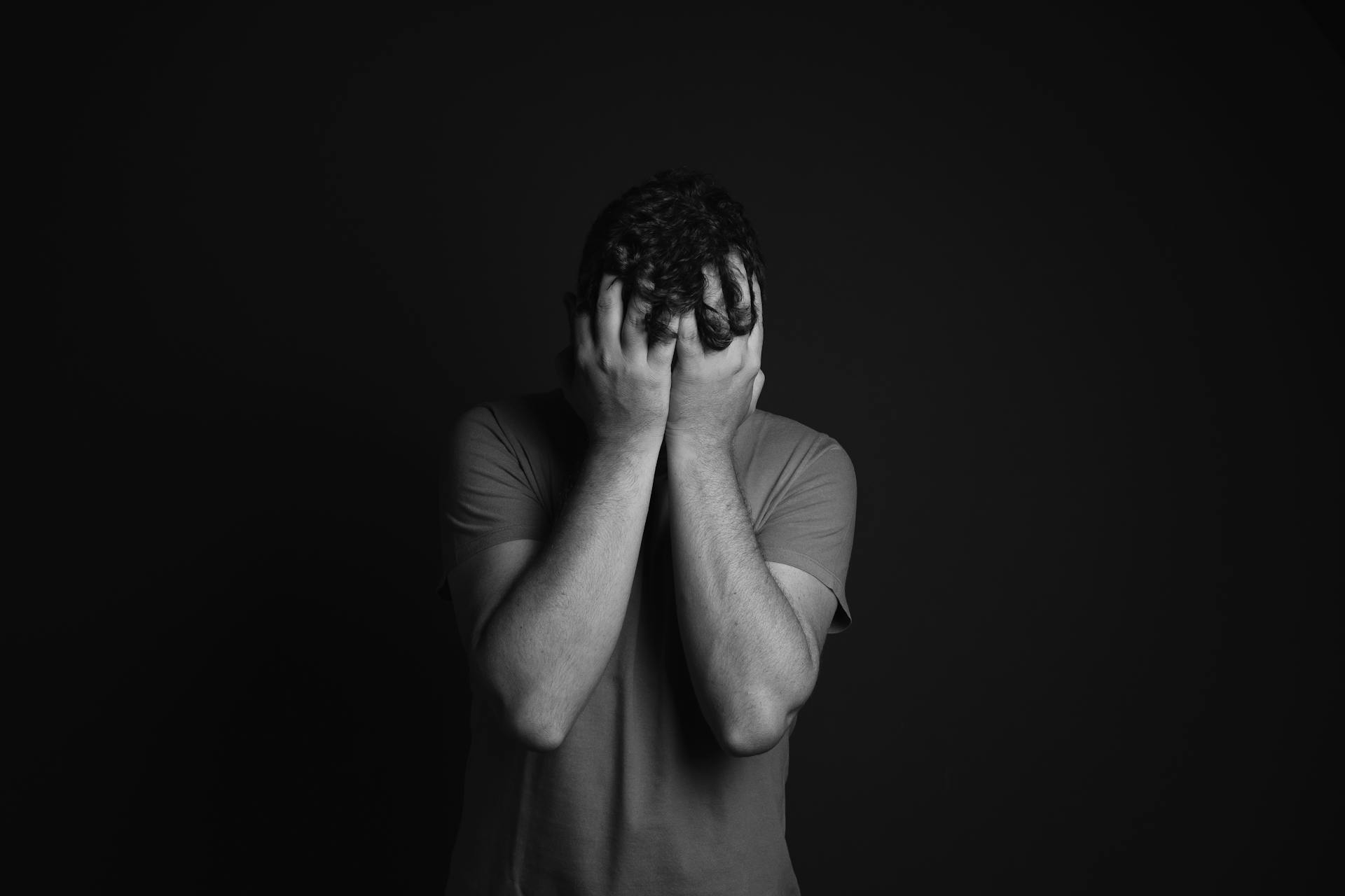 Un homme debout, les mains sur le visage | Source : Pexels
