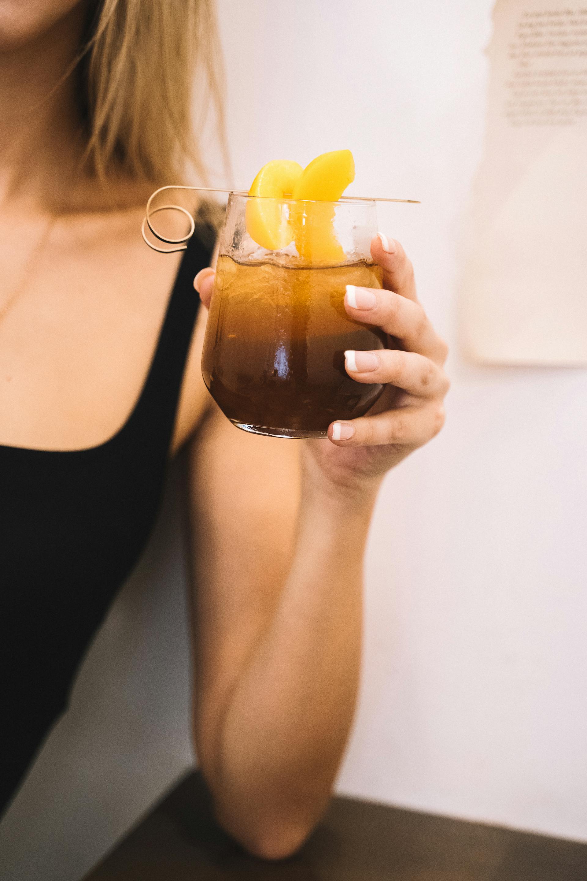 Une femme tenant une tasse de thé glacé | Source : Pexels
