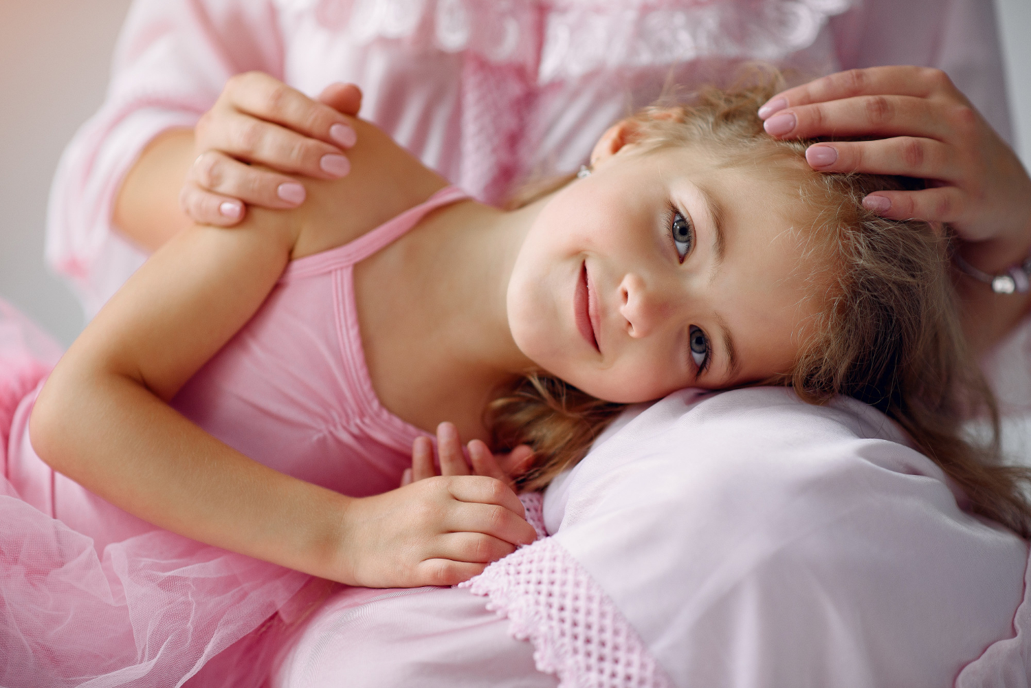 Une petite fille allongée sur les genoux de sa mère | Source : Freepik