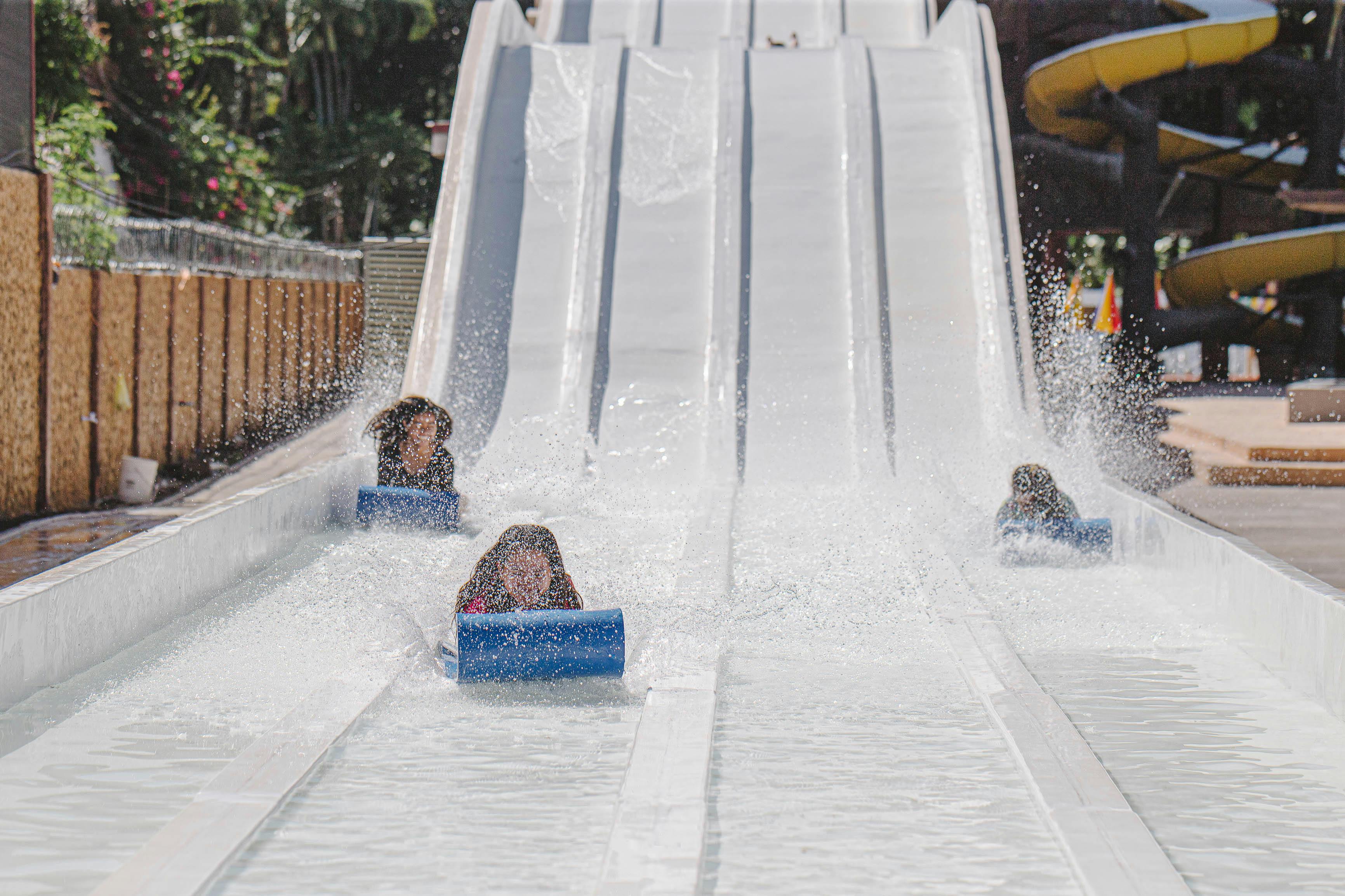 Personnes descendant un toboggan aquatique | Source : Pexels