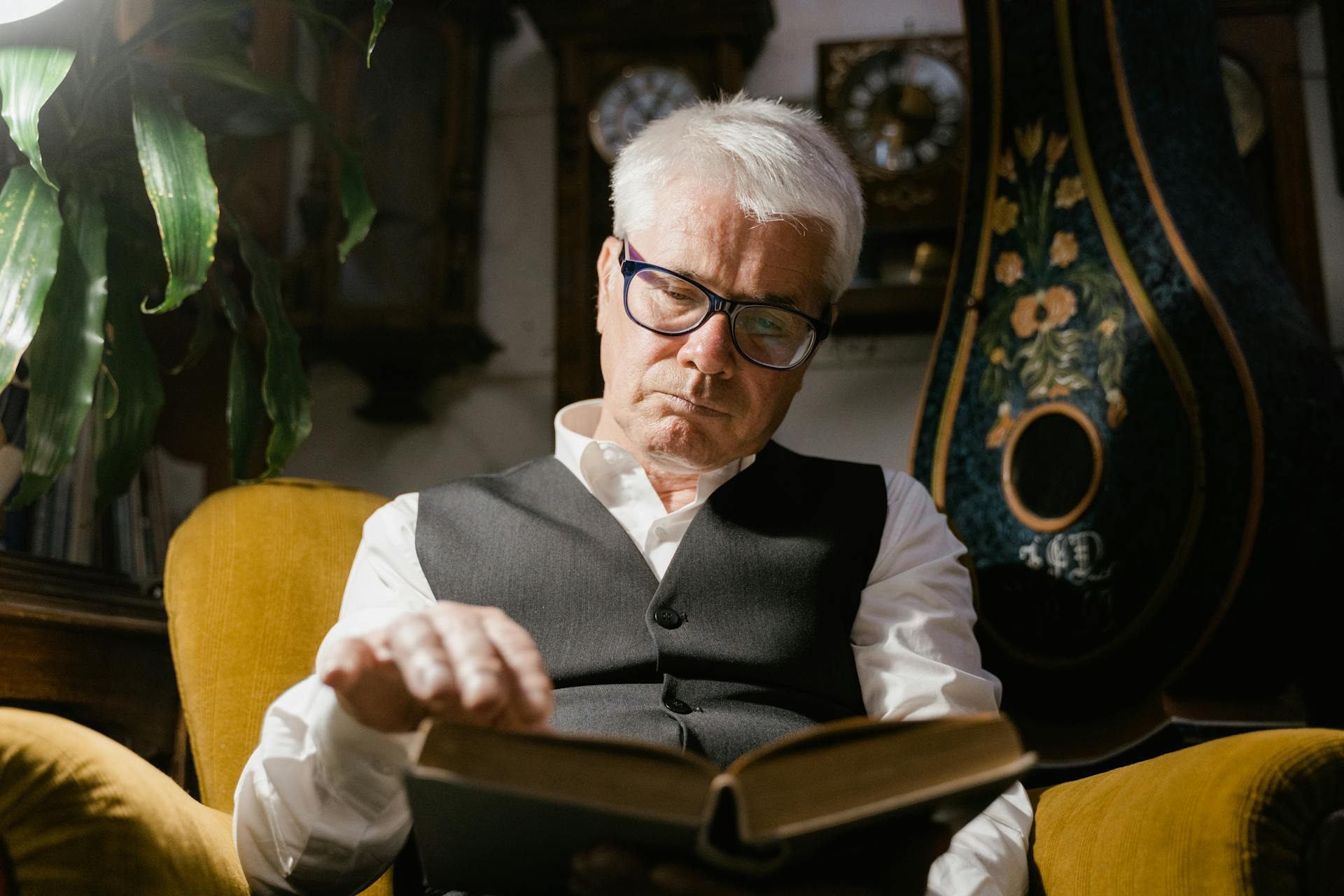 Un homme lisant dans un fauteuil | Source : Pexels