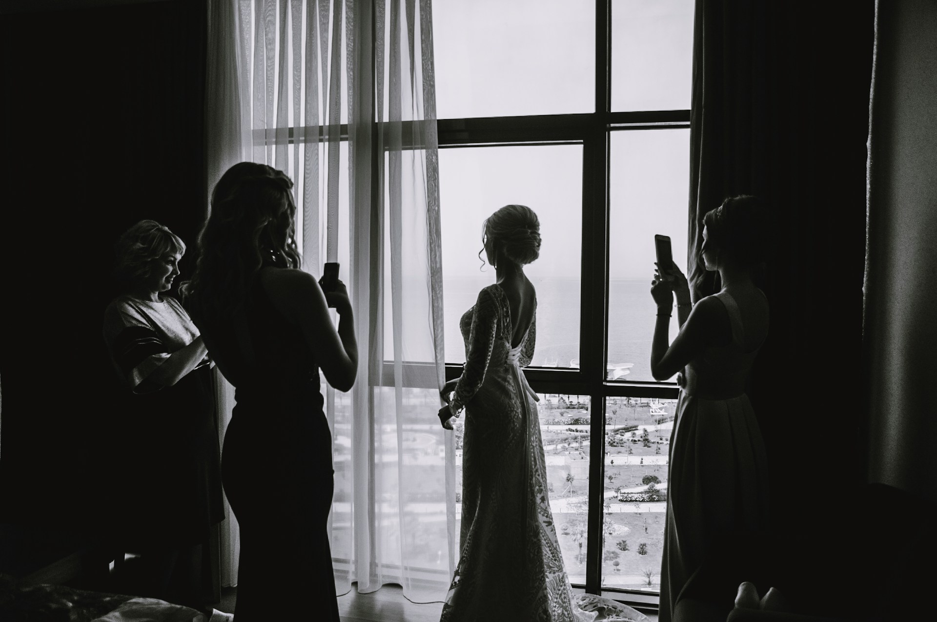 Femmes prenant des photos d'une mariée dans sa suite | Source : Unsplash