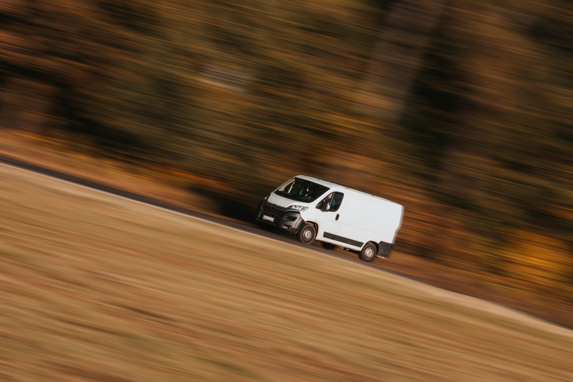 Une camionnette de livraison roulant à toute allure sur une route | Source : Unsplash
