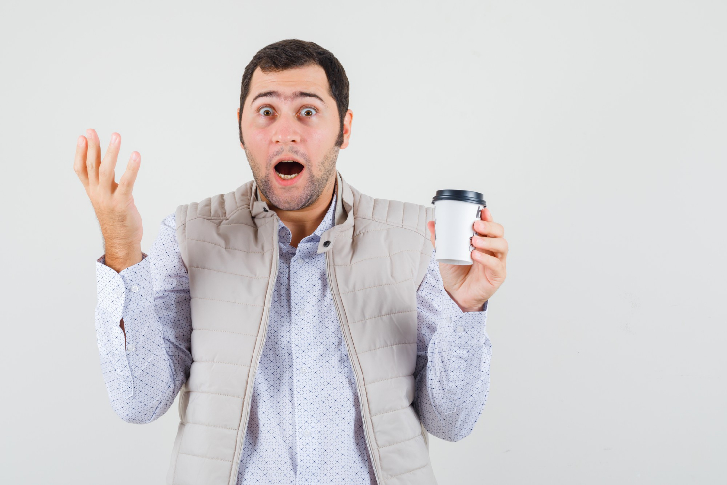 Un homme choqué tenant une tasse de café | Source : Freepik