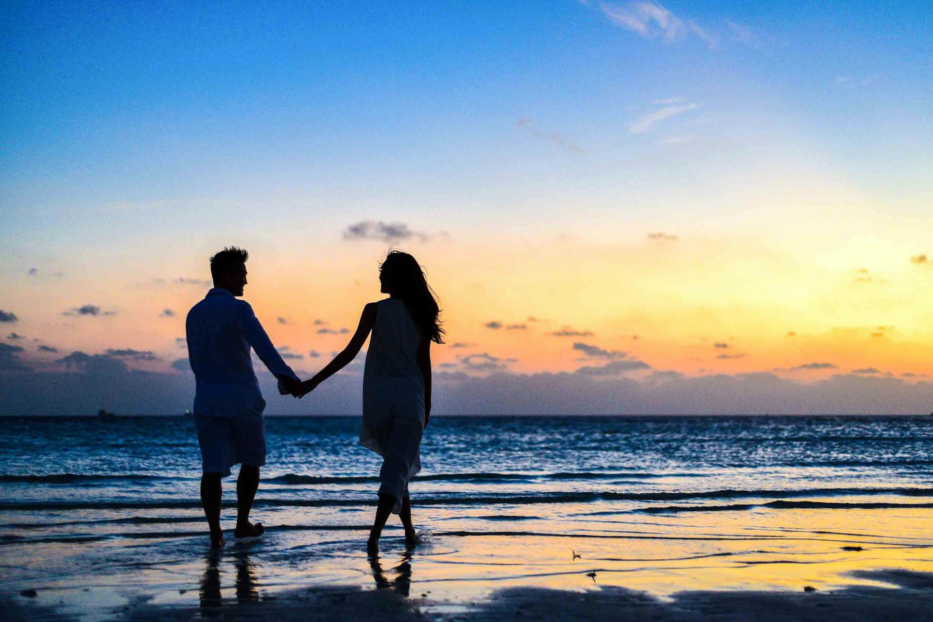 Un couple qui se tient par la main au bord de la mer | Source : Pexels